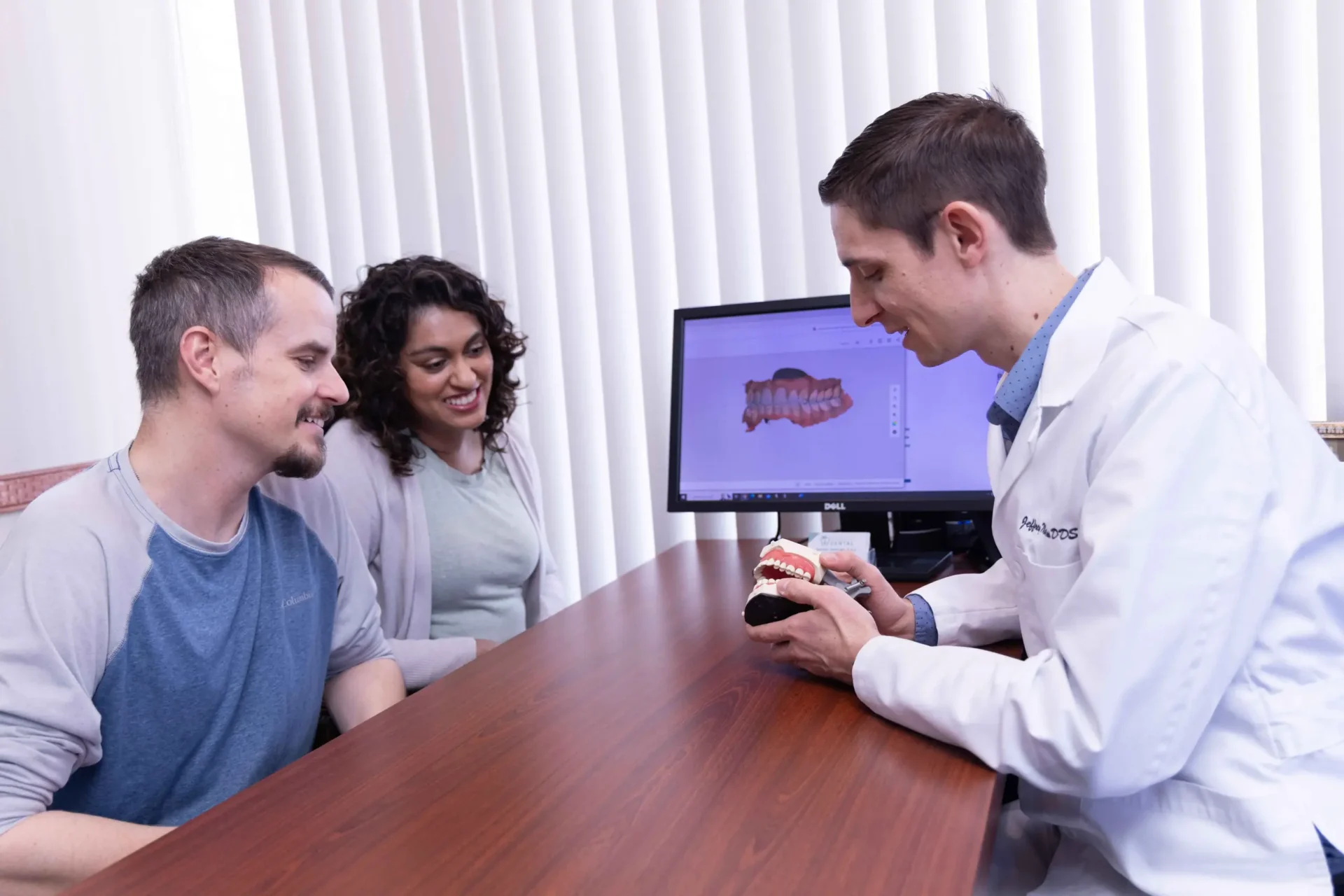 Doctor explaining dental model to couple
