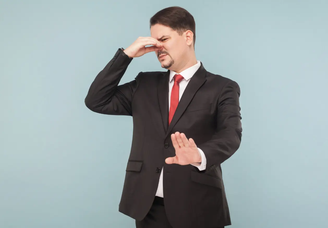Man in suit reacting to odor