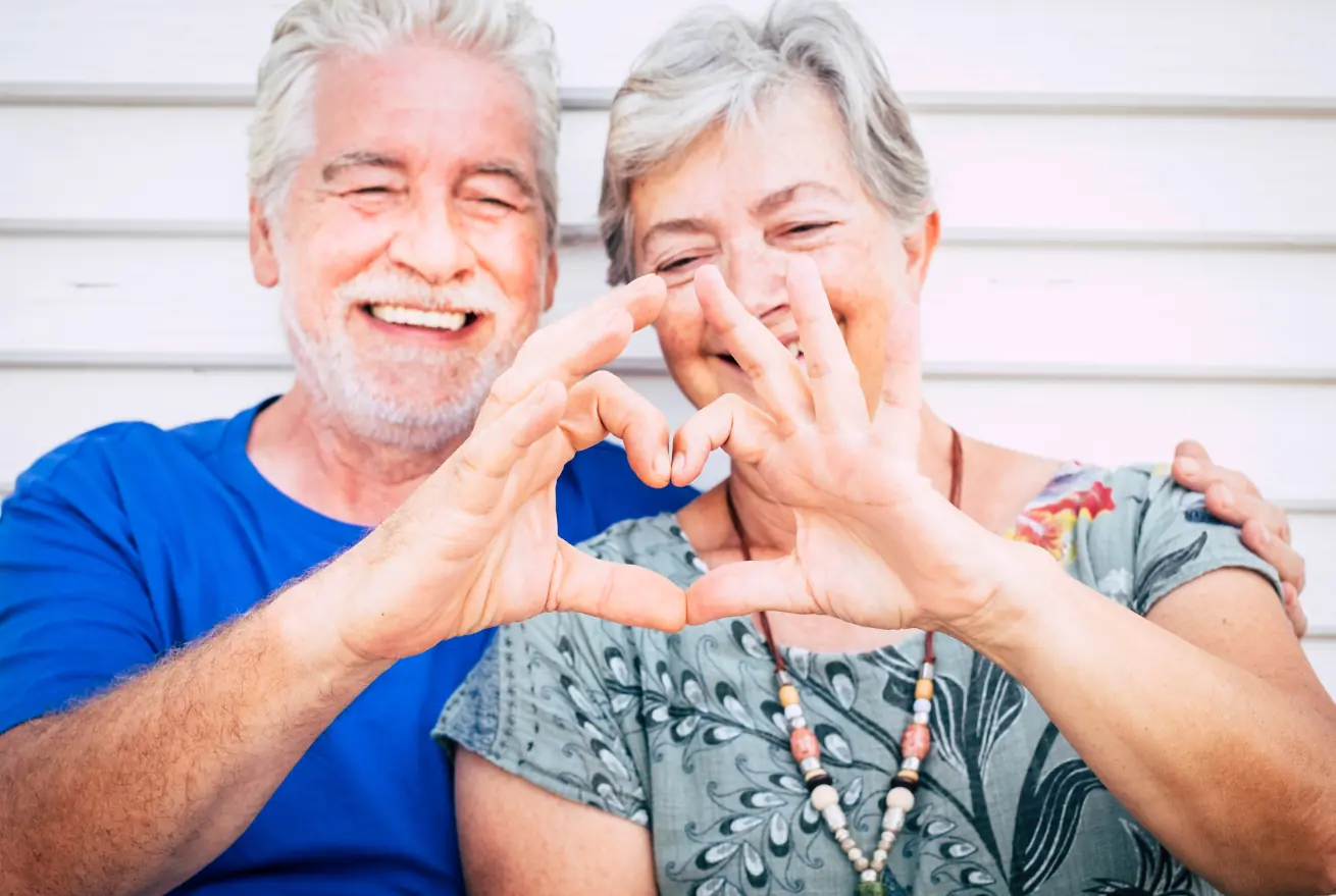 Elderly couple making heart shape