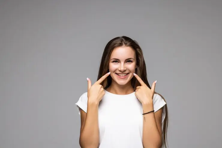 Smiling woman pointing at her teeth
